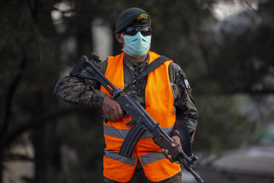 Un soldado está apostado en un punto de control durante el cuarto día del toque de queda para prevenir la propagación del nuevo coronavirus en Villa Nueva, Guatemala, el miércoles 25 de marzo de 2020. (AP Foto / Moises Castillo)