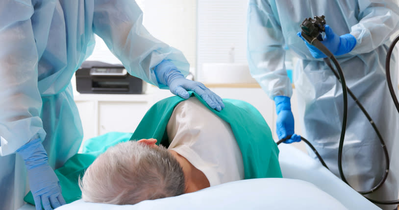 Health professionals in protective gear caring for a patient in a medical setting