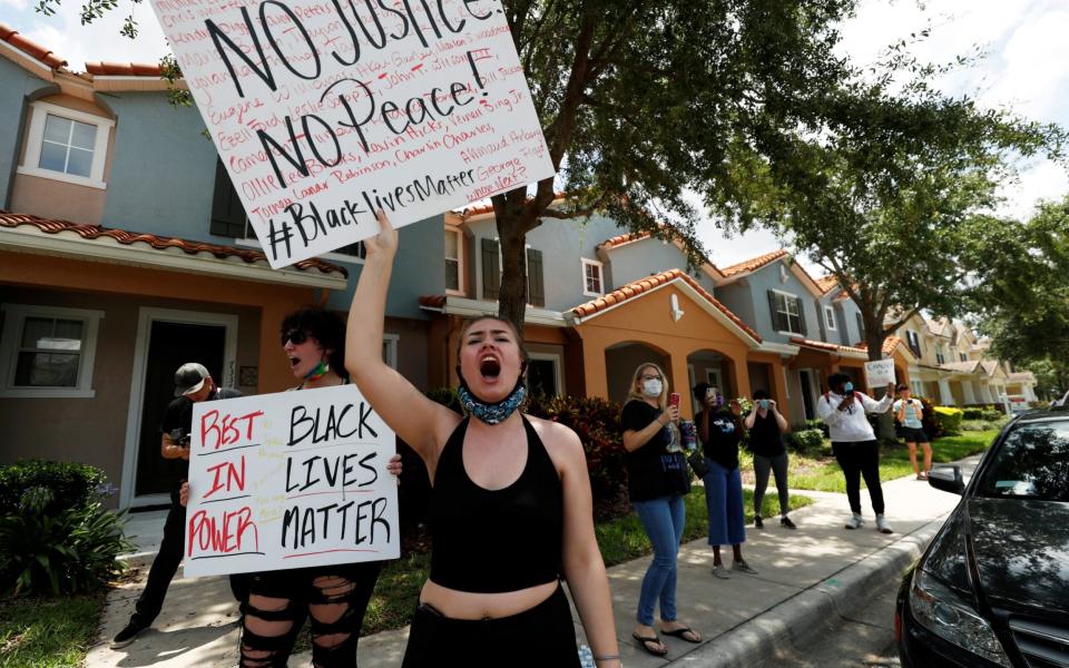 Protesters react to the news of the arrest of former Minneapolis police officer Derek Chauvin outside his Florida home in Windermere - Reuters