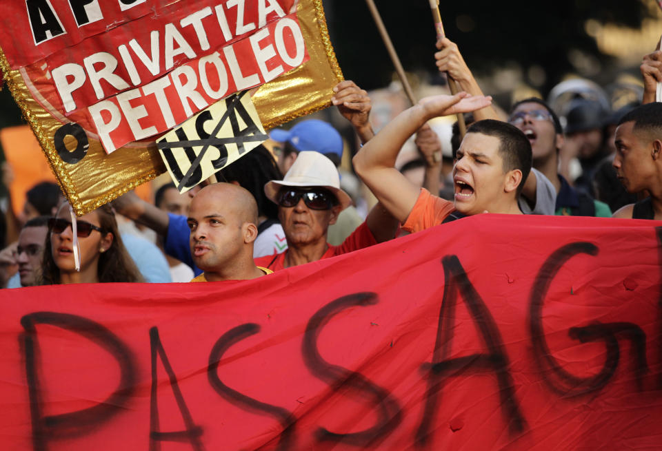 Demonstrators shout slogans during a protest against a 10-cent hike in bus fares in Rio de Janeiro, Brazil, Thursday, Feb. 13, 2014. Some roads in the center of Rio, which will serve as the 2016 Olympic city, were blocked Thursday night as demonstrators carried banners calling for a reversal of the fare hike, along with more investments in education and health care. (AP Photo/Silvia Izquierdo)
