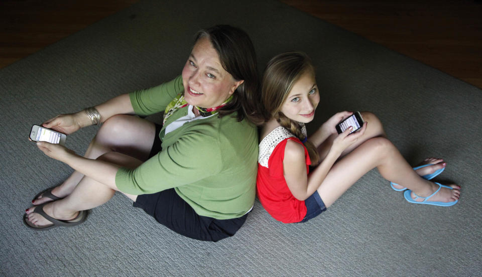 In this Thursday, May 24, 2012 photo, Anna Schiferl, right, sits with her mother, Joanna, holding their cell phones in the living room of their LaGrange, Ill., home. Statistics from the Pew Internet & American Life Project show that, these days, many people with cell phones prefer texting over a phone call. It’s not always young people, though the data indicates that the younger you are, the more likely you are to prefer texting. But many experts say the most successful communicators will, of course, have the ability to do both talk or text, and know the most appropriate times to use those skills. (AP Photo/Charles Rex Arbogast)