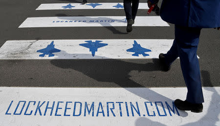 FILE PHOTO - Trade visitors are seen walking over a road crossing covered with Lockheed Martin branding at Farnborough International Airshow in Farnborough, Britain, July 17, 2018. REUTERS/Toby Melville/File Photo