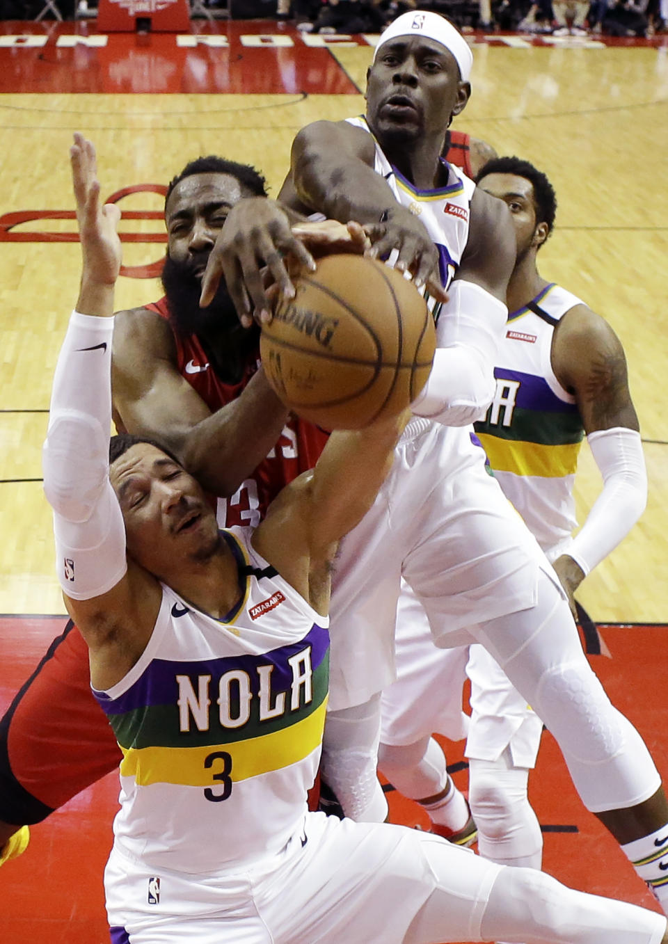 New Orleans Pelicans guards Josh Hart (3) and Jrue Holiday, top, vie with Houston Rockets guard James Harden, center, for a rebound during the first half of an NBA basketball game, Sunday, Feb. 2, 2020, in Houston. (AP Photo/Eric Christian Smith)