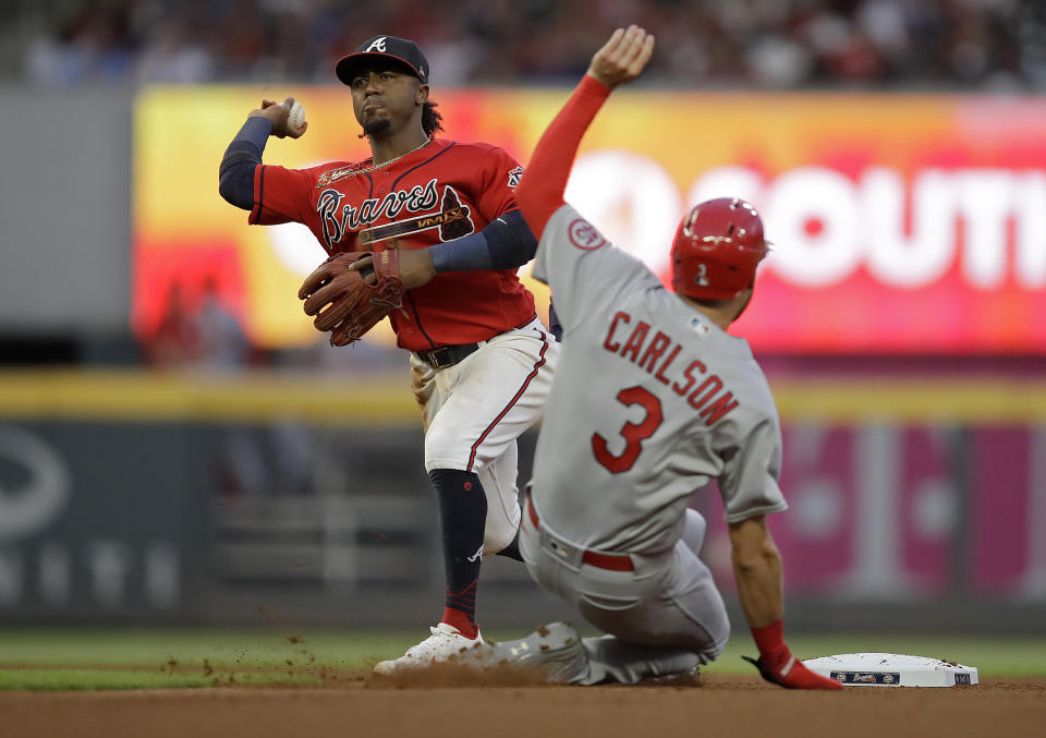 Atlanta Braves' Ozzie Albies, left, prepares his throw to first base to complete a double play after making the out on St. Louis Cardinals' Dylan Carlson (3) during the fourth inning of a baseball game Friday, June 18, 2021, in Atlanta. Cardinals' Nolan Arenado was out at first base. (AP Photo/Ben Margot)