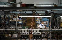 Workers of the Calzaturificio M.G.T shoe factory in Castelnuovo Vomano, central Italy, return to work, Monday, May 4, 2020. Italy began stirring again Monday after a two-month coronavirus shutdown, with 4.4 million Italians able to return to work and restrictions on movement eased in the first European country to lock down in a bid to stem COVID-19 infections. (AP Photo/Domenico Stinellis)