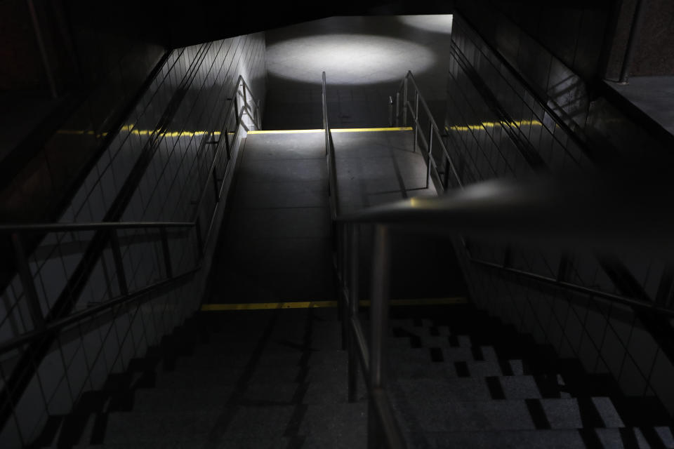 Stairs leading down to the C and E trains at the 50th Street Subway Station are dimly lit during a power outage, Saturday, July 13, 2019, in New York. Authorities were scrambling to restore electricity to Manhattan following a power outage that knocked out Times Square's towering electronic screens and darkened marquees in the theater district and left businesses without electricity, elevators stuck and subway cars stalled. (AP Photo/Michael Owens)