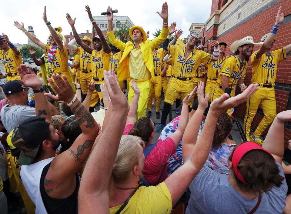 The Savannah Bananas, led by owner Jesse Cole, center, dance and sing with fans outside the Canal Park before the Savannah Bananas' World Tour stop Monday in Akron.