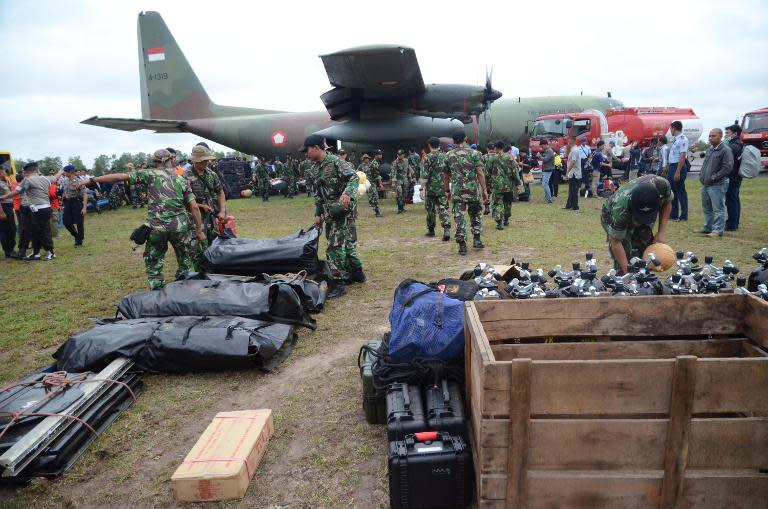 Members of the Indonesia marines unload their diving equipment as they arrive at Pangkalan Bun air base in Central Kalimantan on December 31, 2014, to join the operation to find AirAsia flight QZ8501