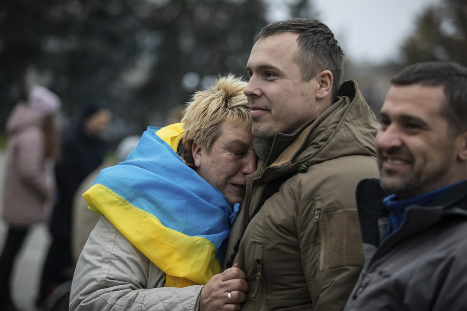 A woman leans on Ukrainian lawmaker and officer Roman Kostenko as they celebrate the recapturing in Kherson, Ukraine, Saturday, Nov. 12, 2022. People across Ukraine awoke from a night of jubilant celebrating after the Kremlin announced its troops had withdrawn to the other side of the Dnieper River from Kherson. The Ukrainian military said it was overseeing "stabilization measures" around the city to make sure it was safe. (AP Photo/Yevhenii Zavhorodnii)