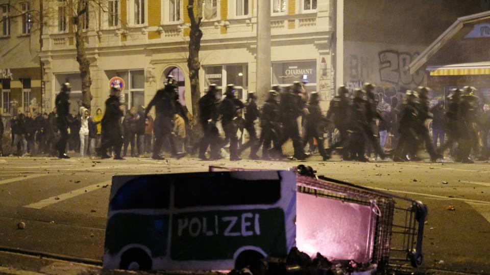 Polizisten räumen in der Neujahrsnacht eine Kreuzung im Leipziger Stadtteil Connewitz.