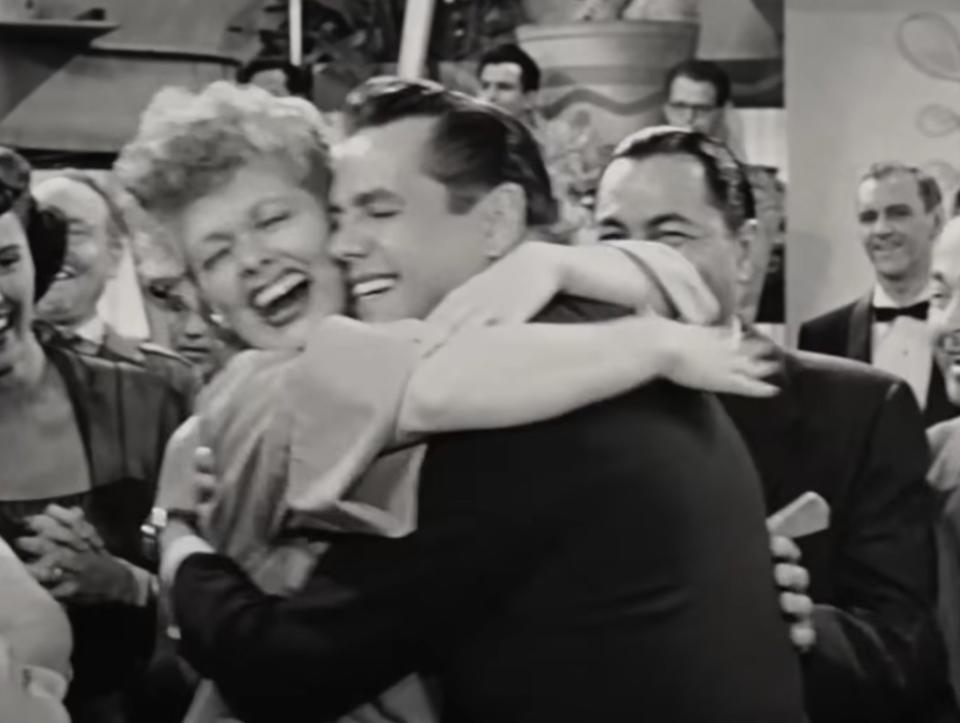 Lucy and Desi laugh and hug on the "I Love Lucy" set