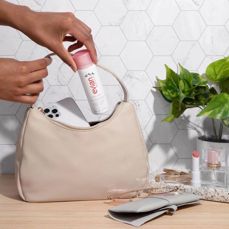 A model inserting the spray into a handbag