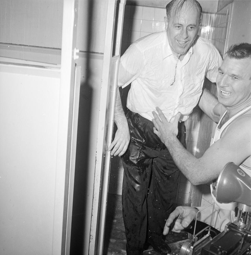 Boston Celtics coach Red Auerbach is assisted from shower by Jim Loscutoff where he was placed by players after the Celtics defeated the <a class="link " href="https://sports.yahoo.com/nba/teams/atlanta/" data-i13n="sec:content-canvas;subsec:anchor_text;elm:context_link" data-ylk="slk:St. Louis Hawks;sec:content-canvas;subsec:anchor_text;elm:context_link;itc:0">St. Louis Hawks</a> 121-112 to win the NBA championship at Boston Garden last night. It was the Celtics third straight NBA championship and fourth in five years. AP Photo/J. Walter Green