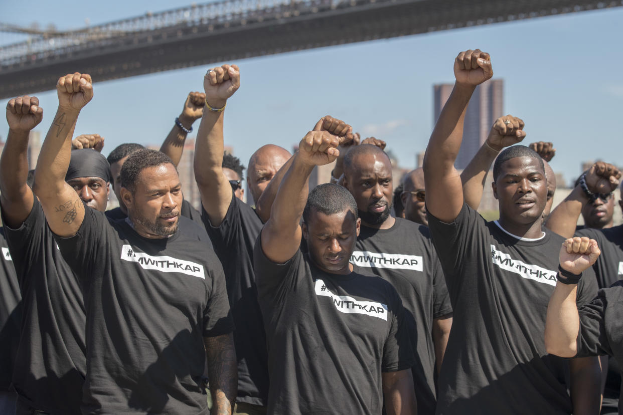 Members of law enforcement raise their fists during a rally in New York to show support for Colin Kaepernick. (AP)