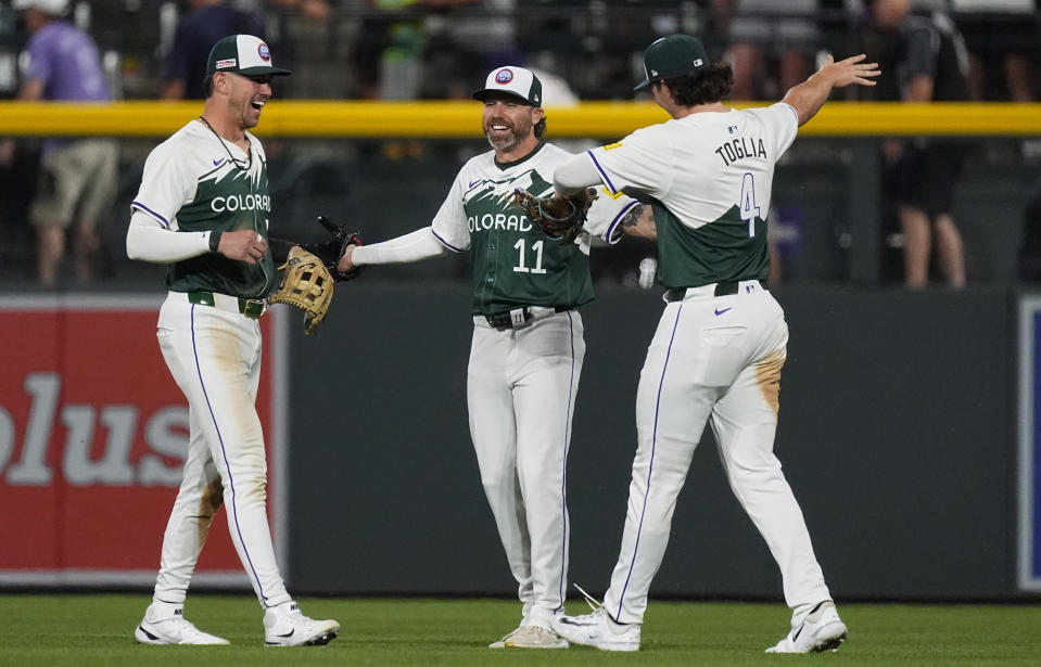 Colorado Rockies left fielder Nolan Jones, center fielder Jake Cave and right fielder Michael Toglia, from left, celebrate the team's win in a baseball game against the Pittsburgh Pirates on Saturday, June 15, 2024, in Denver. (AP Photo/David Zalubowski)