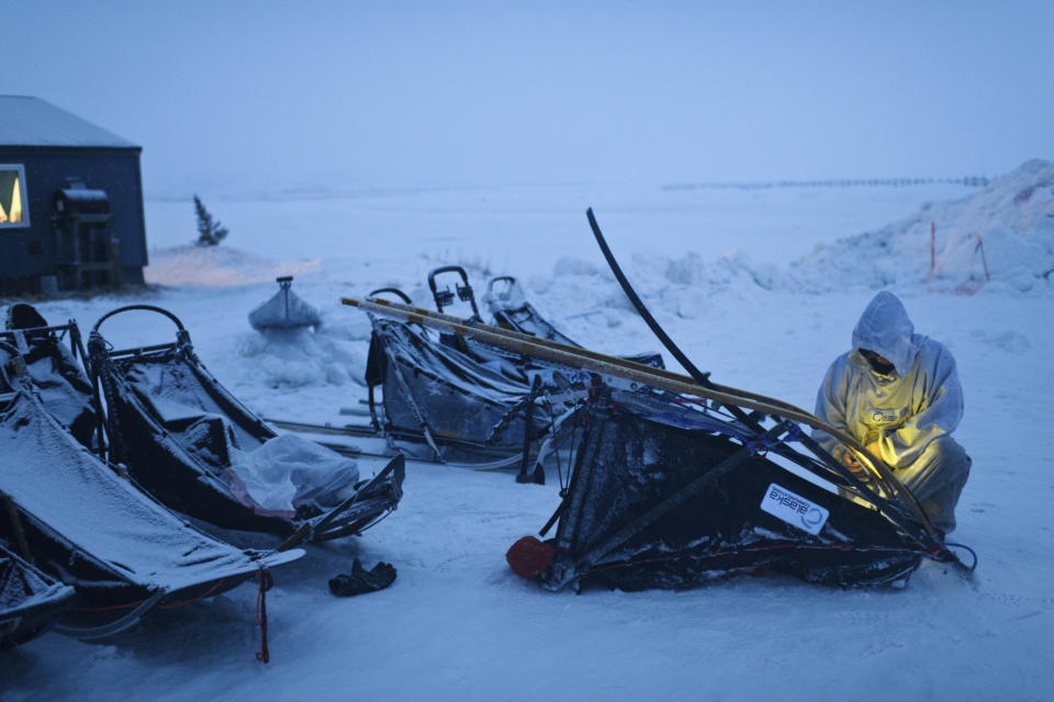 In this Monday, March 11, 2019 photo, musher Ramey Smyth changes runners as he switches sleds in Unalakleet, Alaska, during the Iditarod Trail Sled Dog Race. (Marc Lester/Anchorage Daily News via AP)