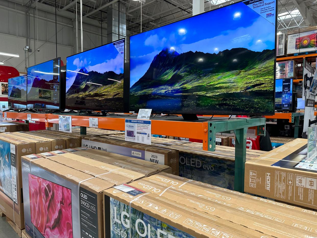 Big-screen televisions stand on display in a Costco warehouse Wednesday, May 10, 2023, in Sheridan, Colo.  Buy now, pay later loans let people pay for big-ticket items like electronics in installments.