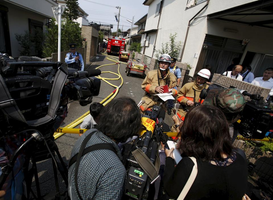 A spokesperson from Tokyo Fire Department speaks to the media in front of the site where a light plane went down in a residential area and burst into flames, in Chofu