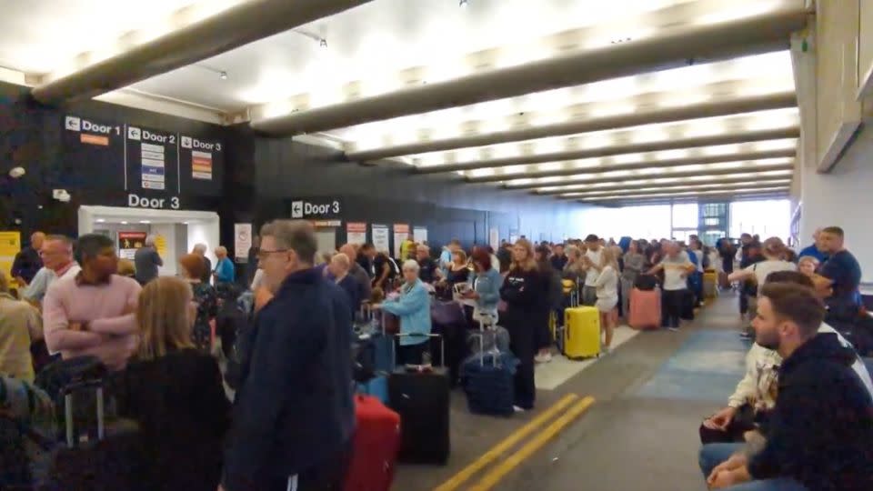 In a screengrab taken from a video, travelers wait around at Terminal One of the Manchester Airport in Manchester England on June 23, 2024, as a power cut let to disruptions and cancelations. - Chris Shaw