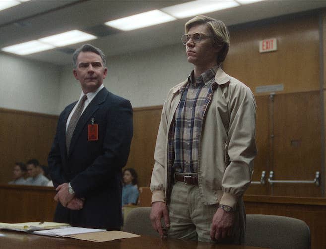 Evan as Jeffrey Dahmer in court standing next to his lawyer