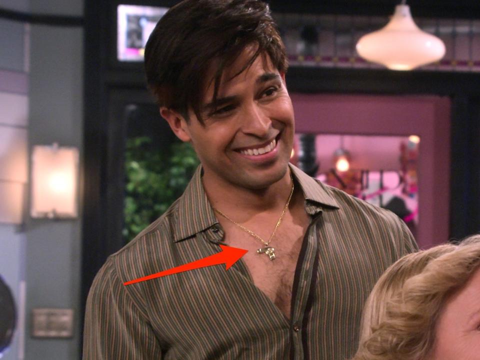 An arrow pointing to Fez wearing a hairdryer necklace on season one, episode three of "That '90s Show."