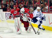RALEIGH, NC - MARCH 03: Cam Ward #30 of the Carolina Hurricanes slaps the puck away from Tim Wallace #20 of the Tampa Bay Lightning during play at the RBC Center on March 3, 2012 in Raleigh, North Carolina. (Photo by Grant Halverson/Getty Images)