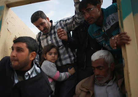 Displaced Iraqis who fled their homes get out of a truck as Iraqi forces battle with Islamic State militants, in western Mosul, Iraq March 28, 2017. REUTERS/Suhaib Salem