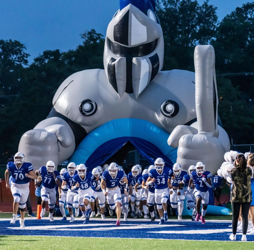 Oak Creek offensive lineman James Thomas (77) runs on to the field with his teammates before the Knights' home game with Franklin on Sept. 21, 2023.