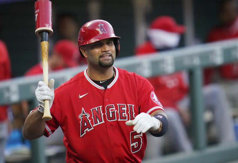 Los Angeles Angels designated hitter Albert Pujols waves to players in the Colorado Rockies.