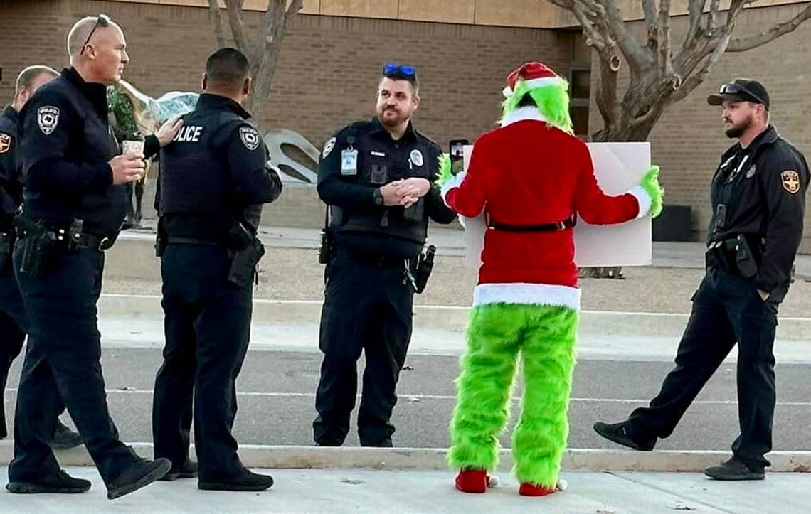 Amarillo police and school district officers responded to street preacher David Grisham’s anti-Santa protest dressed as “The Grinch” Nov. 27, 2023, at Sleepy Hollow Elementary School in Amarillo, Texas. Grisham’s sign read, “SANTA IS / FAKE / JESUS IS / REAL.”