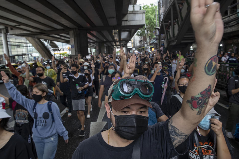 Pro-democracy protesters flash three-fingered salute during a protest in Udom Suk, suburbs of Bangkok, Thailand, Saturday, Oct. 17, 2020. The authorities in Bangkok shut down mass transit systems and set up roadblocks Saturday as Thailand’s capital faced a fourth straight day of determined anti-government protests. (AP Photo/Gemunu Amarasinghe)