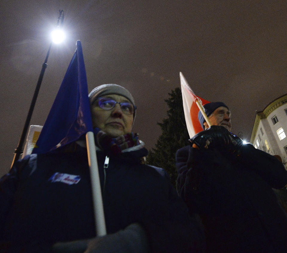 People holding a Poland and European Union flags take part in a protest outside Poland's parliament building as lawmakers voted to approve the much-criticized legislation that allows politicians to fire judges who criticize their decisions, in Warsaw, Poland, Thursday, Jan. 23, 2020. Poland's lawmakers gave their final approval Thursday to legislation that will allow politicians to fire judges who criticize their decisions, a change that European legal experts warn will undermine judicial independence. (AP Photo/Czarek Sokolowski)