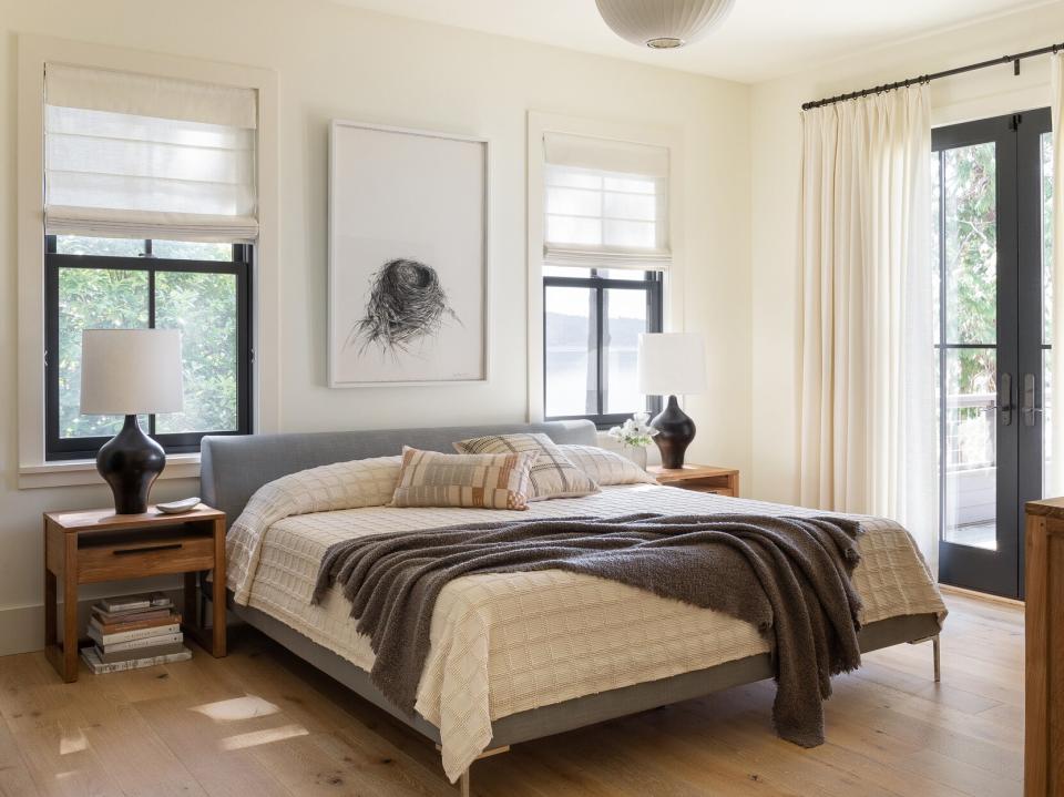 master bedroom with print of birds nest hanging above bed