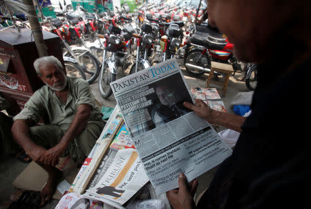 A man reads a newspaper with news about the disqualification of Pakistan's Prime Minister Nawaz Sharif by the Supreme Court, at a news stand in Peshawar, Pakistan July 29, 2017. REUTERS/Fayaz Aziz