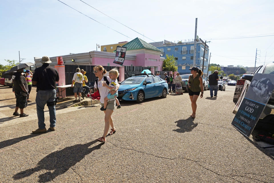 A mother and child walk past the Jackson Women's Health Organization Clinic (Rogelio V. Solis / AP)