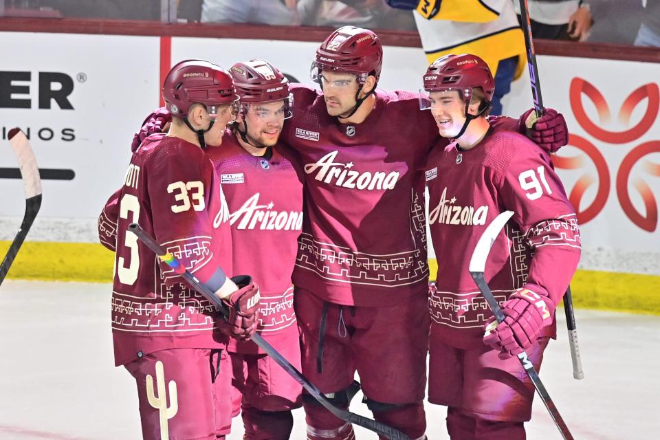 Arizona Coyotes center Jack McBain (22) celebrates with teammates after scoring a goal.