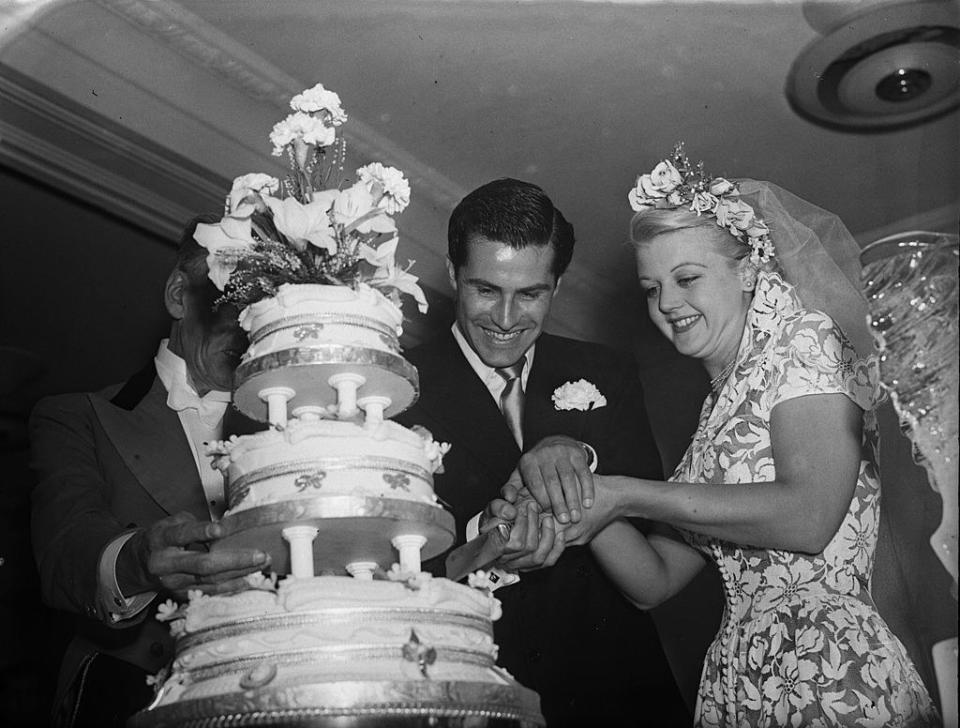 Lansbury and her husband, Peter Shaw, cutting the cake at their wedding.