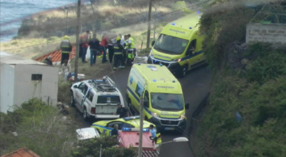 In this image from video, emergency services attend the scene after a tour bus crashed at Canico, on Portugal's Madeira Island, Wednesday April 17, 2019. Some 28 people are reported to have died in the crash, most of them German tourists, local mayor Filipe Sousa told TV news. (TVI via AP)