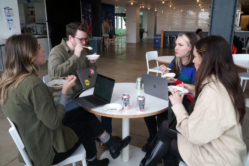 Four people sitting at a table and eating