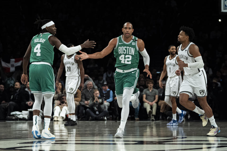 Boston Celtics' Jrue Holiday (4) congratulates Al Horford (42) during the first half of the team's NBA basketball game against the Brooklyn Nets in New York, Tuesday, Feb. 13, 2024. (AP Photo/Peter K. Afriyie)