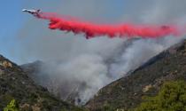 Firefighters battle a blaze from the air that was threatening homes in the Pacific Palisades community of Los Angeles, California