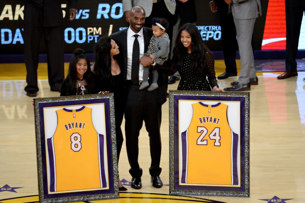 Kobe Bryant poses with his family at the retirement ceremony for both of his Laker’s jerseys.