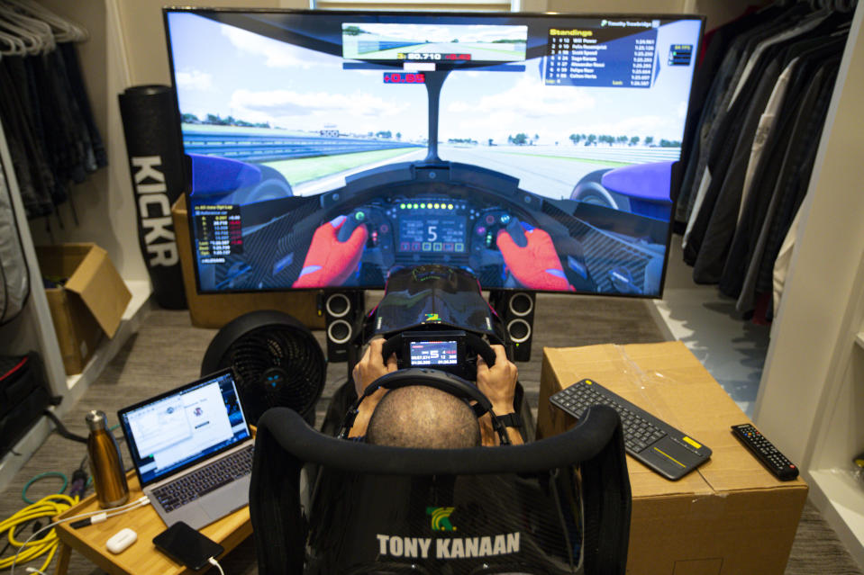 FILE - In this March 28, 2020, file photo, IndyCar driver Tony Kanaan, of Brazil, uses a racing simulator in his home in Indianapolis to practice for a virtual racing event. As Robert Wickens fought his way back from a spinal cord injury, he kept dreaming about the day he could run against his old racing buddies. The promising Canadian driver believes he'll take his biggest step yet by making his debut in the IndyCar iRacing Challenge — a virtual race being held Saturday, April 4, 2020, on the Barber Motorsports Track in Alabama. (AP Photo/Michael Conroy, File)