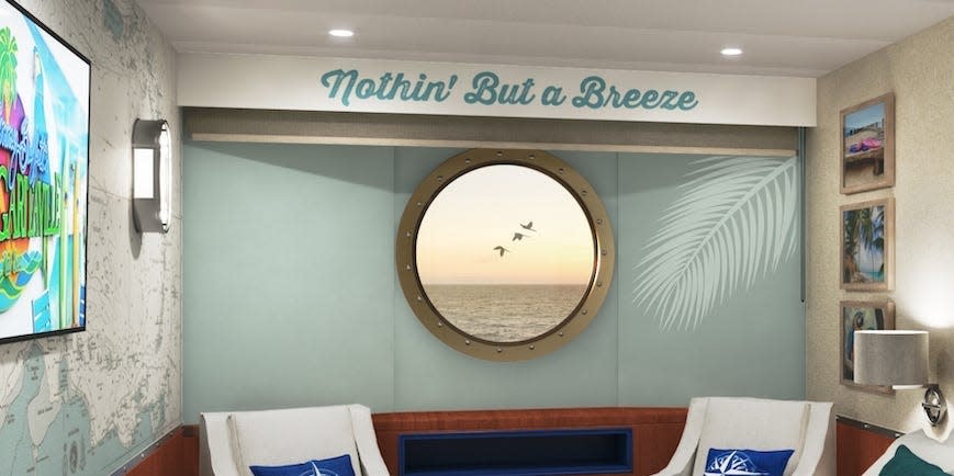 A stateroom aboard the Margaritaville Paradise with a bed, window, and chairs