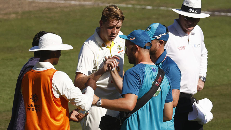 Cameron Green confers with trainers for Australia after being hit on the finger in the first innings of the Boxing Day Test.