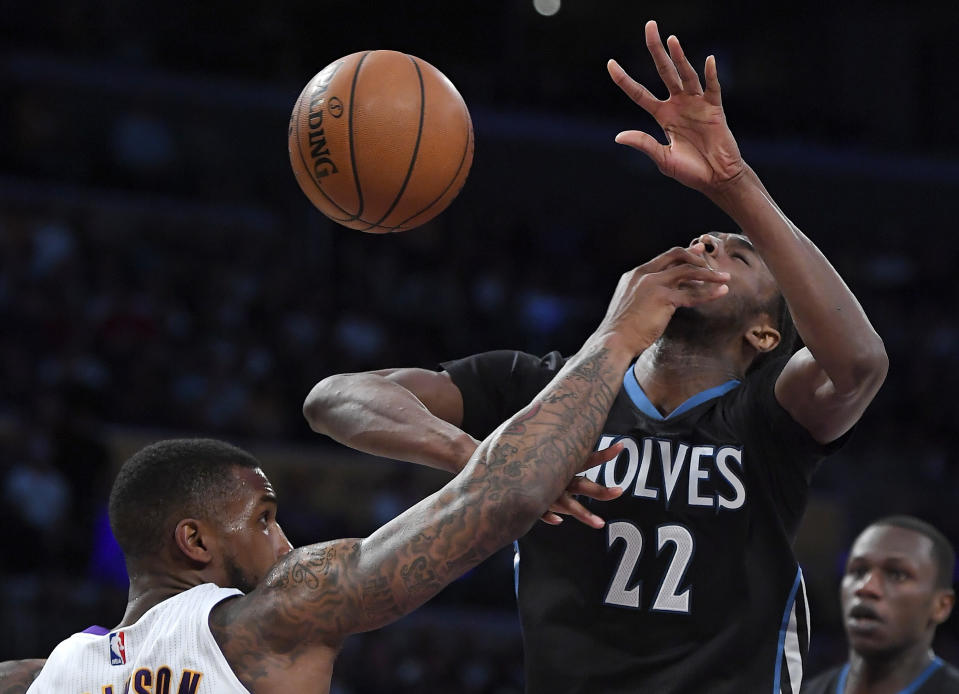 Minnesota Timberwolves forward Andrew Wiggins, right, is hit in the face by Los Angeles Lakers forward Thomas Robinson as he tries to shoot during the first half of an NBA basketball game, Sunday, April 9, 2017, in Los Angeles. (AP Photo/Mark J. Terrill)
