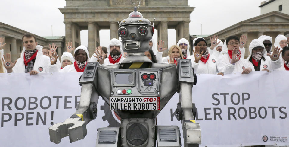 People take part in a 'Stop killer robots' campaign at Brandenburg gate in Berlin, Germany, Thursday, March 21, 2019. (Wolfgang Kumm/dpa via AP)