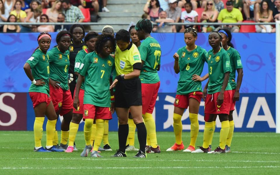 Referee Qin Liang tries to calm the Cameroon players - Getty Images Europe