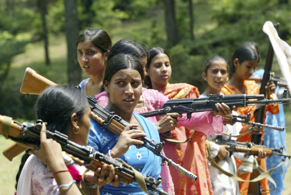 FILE - Women Village Defense Committee (VDC) members look on during a training session by the Indian Army at Sariya village, in Naushera sector, about 140 kilometers (88 miles) northwest of Jammu, India, Aug. 11, 2007. The militia, was initially formed in the 1990s as the first line of defense against anti-India insurgents in remote Himalayan villages that government forces could not reach quickly. As the insurgency waned in their operational areas and as some militia members gained notoriety for brutality and rights violations, drawing severe criticism from human rights groups, the militia was largely disbanded. (AP Photo/Channi Anand, File)