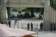 Pakistan's army and police officers stand at the one of the entry point of the Pindi Cricket Stadium before the stat of the first one day international cricket match between Pakistan and New Zealand at the Pindi Cricket Stadium, in Rawalpindi, Pakistan, Friday, Sept. 17, 2021. The limited-overs series between Pakistan and New Zealand has been postponed due to security concerns of the Kiwis. (AP Photo/Anjum Naveed)